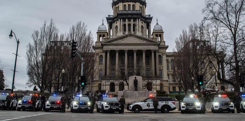 Illinois State Police squad cars are pictured in front of the Illinois State Capitol in 2022 during a 100th anniversary celebration of the agency. A measure headed to the governor would add investigating internet crimes against children to the agency’s core missions.