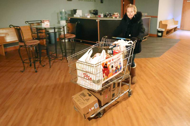 Stage Coach Players Outreach Committee member Jan Kuntz wheels a cart full of donated food items into the theater in DeKalb Tuesday, Nov. 15, 2022, for their Thanksgiving food drive. The group is working with the Salvation Army to put together Thanksgiving meals for local families in need.