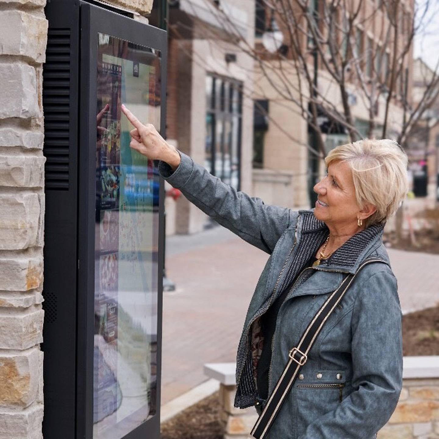 St. Charles community member Elaine Garland uses one of the new digital kiosks now functional at the First Street Plaza downtown.