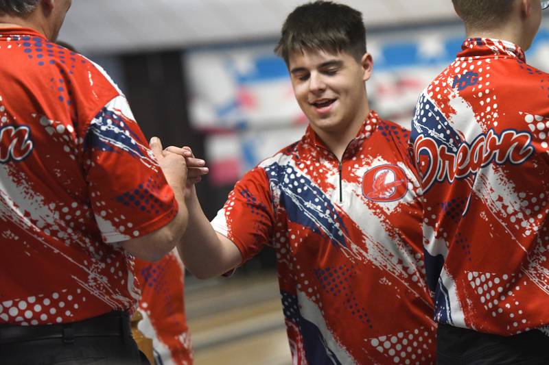 Oregon's Rylann Delehanty celebrates with his teammates and coach Al Nordman after throwing a strike during a match with Harvard at Town & Country Lanes in Mt. Morris on Friday, Dec. 19, 2025.
