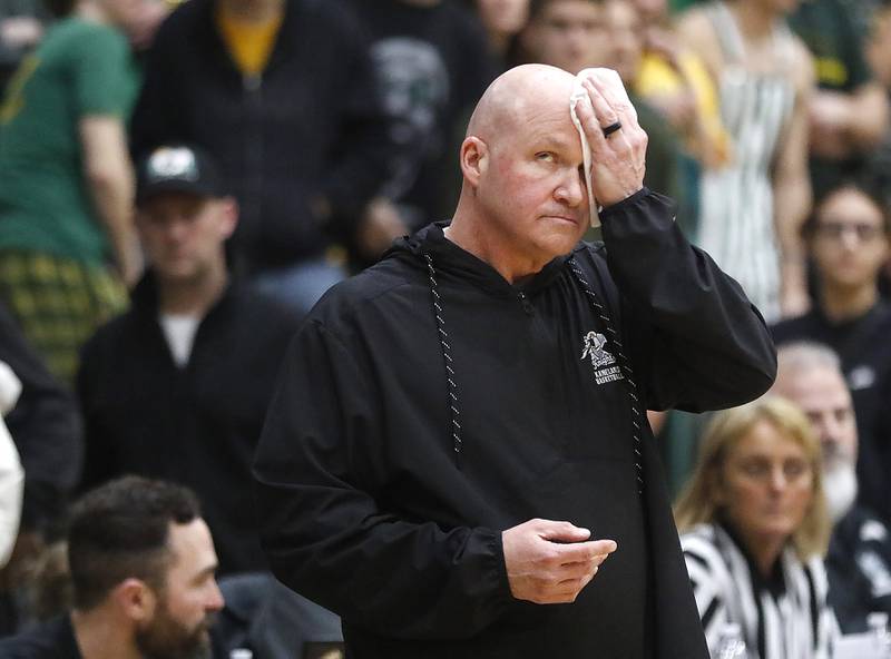 Kaneland Head Coach Ernie Colombe wipes the sweet off his head as he looks at the clock as during the IHSA Class 3A Woodstock North Sectional final basketball game against Crystal Lake South on Friday, March 6, 2026, at Woodstock North High School.