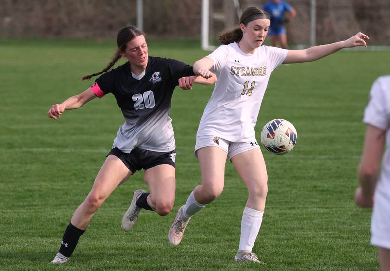 Kaneland's Erin Doucette and Sycamore's Ellie Lawless try to win possession after a throw in during their game Monday, April 13, 2026, at Kaneland High School.