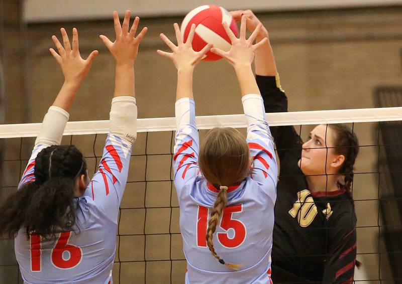 Ottawa's Cheyenne Joachim and Addison Duggan block a spike from Morris's Aubrey Phillips on Tuesday, Sept. 12, 2023 in Kingman Gym at Ottawa High School.