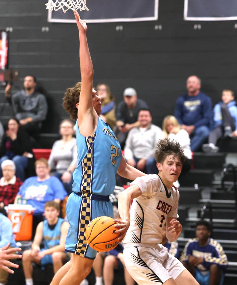 Indian Creek's Jason Brewer passes the ball around Marquette’s Lucas Craig Monday, Dec. 9, 2025, during their game at Indian Creek High School in Shabbona.