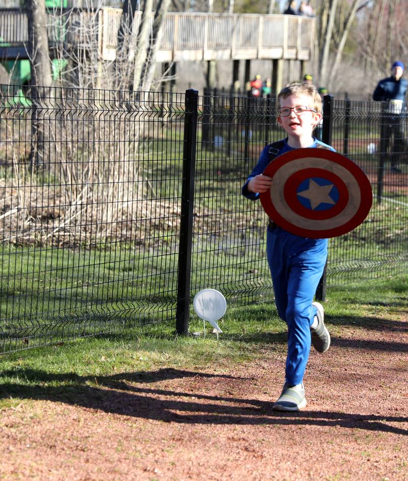 Charlie Austin, 8, of West Chicago, dressed as Captain America, participates in the Wheaton Park District’s Superhero 3K Fun Run at the Sensory Garden Playground in Lisle on Saturday, April 6, 2024.