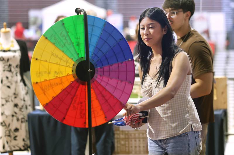 Isamar Lopez, a sophmore at Northern Illinois University, spins the prize wheel Thursday, April 23, 2026, at one of the booths during the DeKalb Chamber of Commerce Local Showcase in the Convocation Center at NIU in DeKalb.