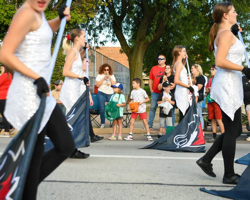 Lacey Meyer, 5 years old, Forrest Vargas, 8 years old, and Conner McDillon, 7 years old, all from Yorkville, watch as the Yorkville High School band marches past during the homecoming parade held in Yorkville on Thursday, Sept. 28, 2023.