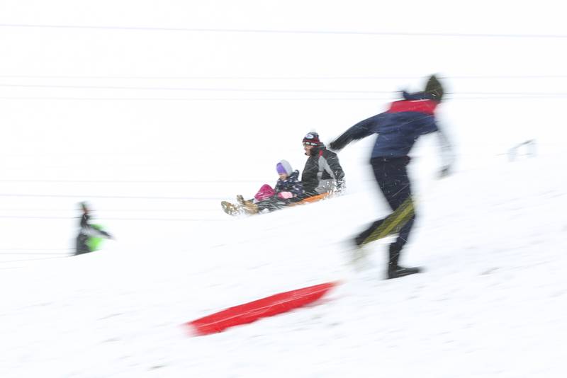 Sledders speed down the hill on Sunday, Jan. 31, 2021, at Cene's Four Seasons Park in Shorewood, Ill. Nearly a foot of snow covered Will County overnight, resulting in fun for some and challenges for others.