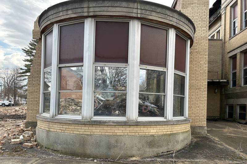 An excavator from Fischer Excavating, of Freeport, can be seen through the round window portion of the Congress School, 208 N. Congress Ave., as demolition continued on Friday, March 28, 2025 in Polo. Demolition of the older, larger portion of the building has been tentatively set to begin Monday.
