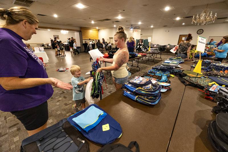 Kim Bork (left), helps mom Alysha Boettger shop for Cooper Full, 5, Thursday, August 7, 2025, at Dixon School’s Tools for School giveaway.