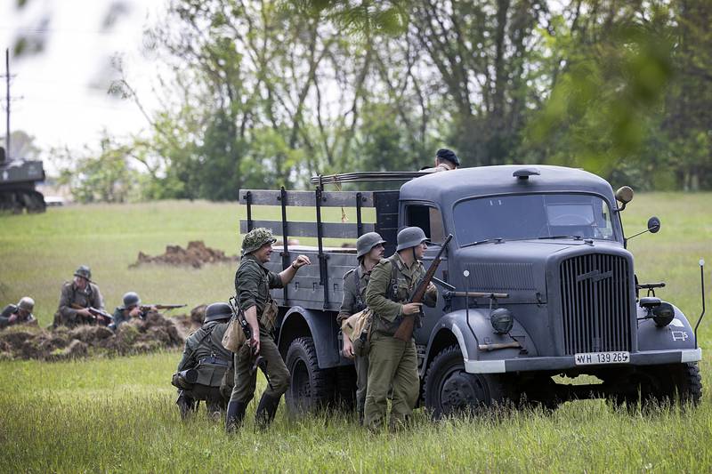 Troops take cover Saturday, May 16, 2026, during a reenactment of the Battle of Anzio in Franklin Grove.