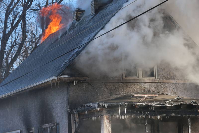 Flames pour out the back of the structure fire as the icicles hang from the porch while firefighters fight a fully engulfed house fire in the 800 block of Bucklin Street on Friday, Jan. 23, 2026 in La Salle.