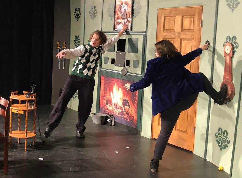 Junior Trekker Kelma (left) tries to hold up the set while answering the phone with sophomore Jillian Younger (right) while rehearsing for "The Play that Goes Wrong" at Mendota High School on Tuesday, Oct. 11, 2022