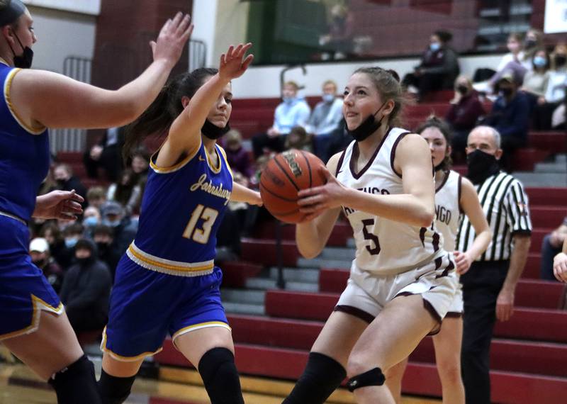 Marengo’s Michaela Almeida prepares to shoot as Johnsburg’s Macy Madsen, left, closes in during girls varsity basketball action in Marengo Thursday night.