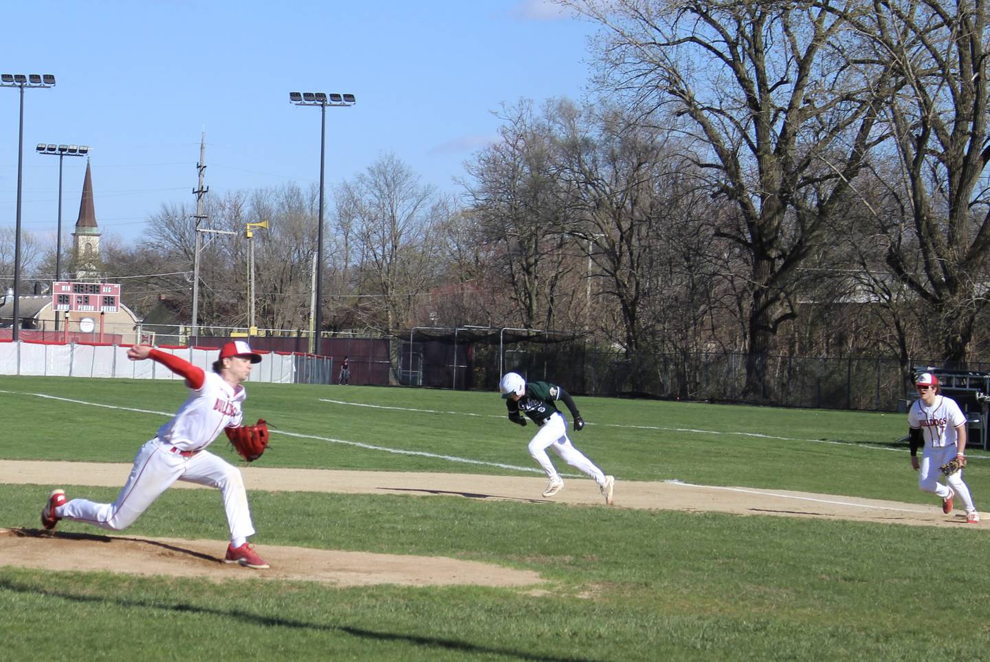 Coal City baserunner Ethan Olson breaks for second as Streator first baseman Cole Winterrowd (far right) holds the bag and Bulldogs starting pitcher Clay Christoff (far left) delivers home Monday, April 6, 2026, in Streator.