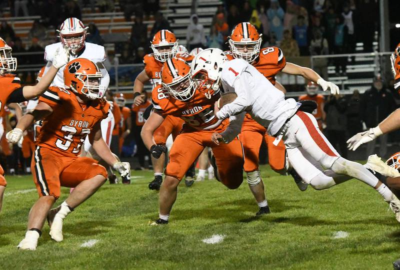 Oregon quarterback Benny Olalde (1) dives for yards as Byron defenders Caden Considine (37) and Jack Jenniges (88) come in to tackle  during 3A football playoff action on Friday, Oct. 31, 2025 at the Everett Stine Stadium in Byron.