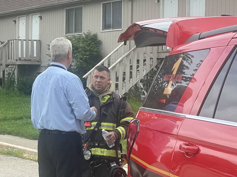 DeKalb Assistant City Manager Bob Redel and Acting Fire Chief Luke Howieson join in conversation Thursday, July 24, 2025, outside an apartment in the 800 block of Edgebrook Drive in DeKalb.