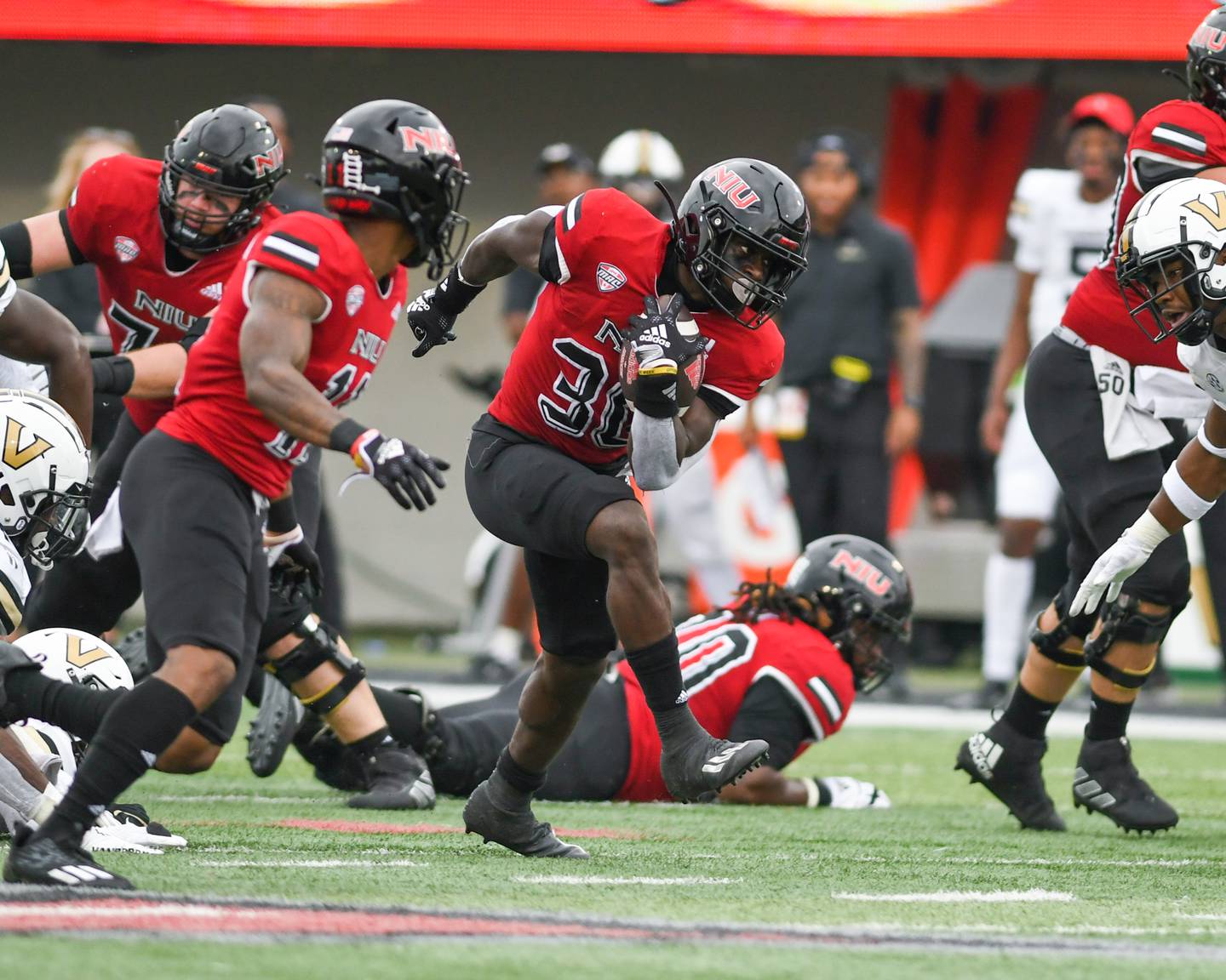 Northern Illinois Huskies Harrison Waylee (30) runs the ball in the second quarter before being brought down by Vanderbilt defenders on Saturday Sep. 17 at Huskie Stadium in DeKalb.