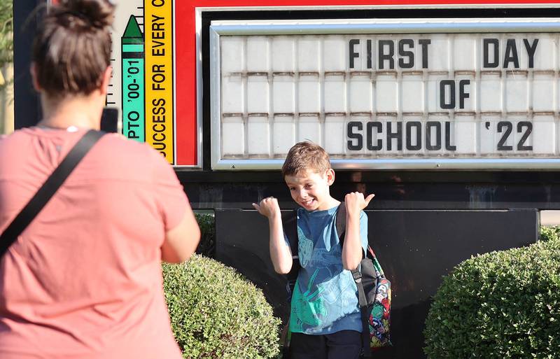 First-grader Wyatt Turner has some fun as his mom Stephanie takes his photo Wednesday, Aug. 17, 2022, during the first day of school at North Elementary in Sycamore.