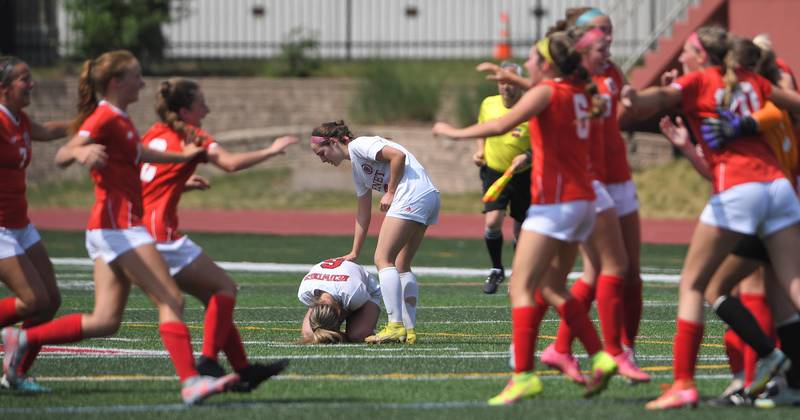 Benet Academy’s Sadie Sterbenz is comforted by teammate Keira Petrucelli as Glenwood celebrates their win in the IHSA girls Class 2A state soccer championship game at North Central College in Naperville on Saturday, June 3, 2023.