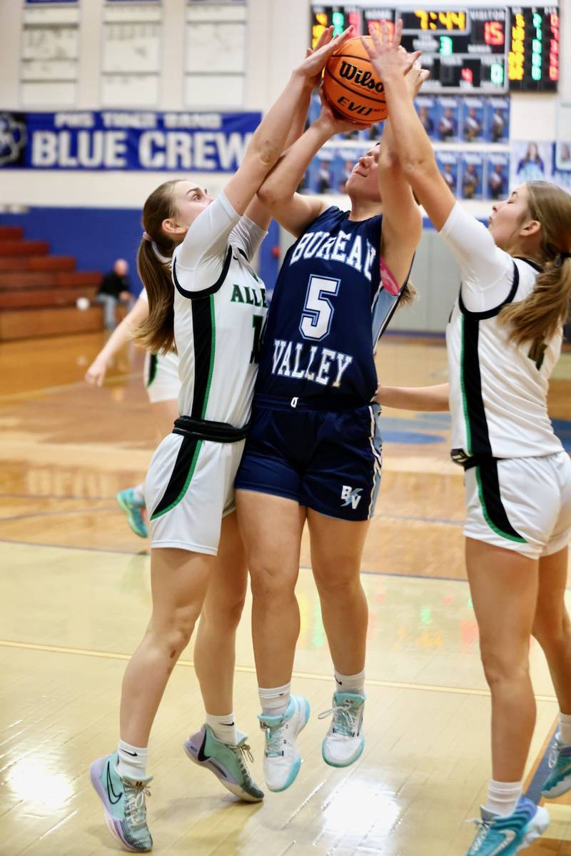 Bureau Valley's Emily Wright gets the squeeze play put on by Alleman's Adalyn Voss (left) and Lilli Lemkpe in regional semifinal play Tuesday at Princeton. The Pioneers won 54-26.