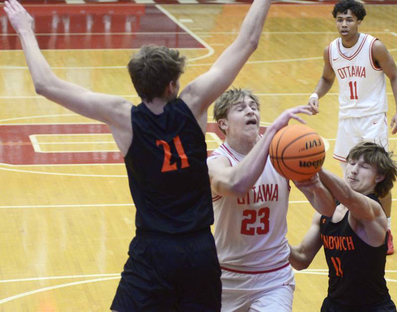 Ottawa’s Owen Sanders fights for a rebound with Sandwich’s EJ Treptow and Nick Michalek in the 1st period Tuesday at Ottawa.