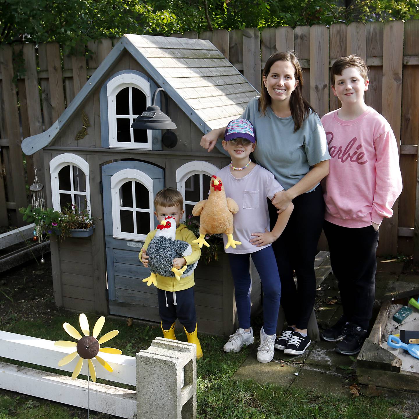 Harvard resident Jessica Helmeid, which her children Myles, Emmaline, and Xavier, with a playhouse that would make a great chicken coop on Tuesday, Sept. 26, 2023. Helmeid is circulating a petition asking the city to allow backyard chickens.