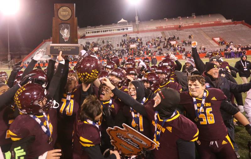Members of the Montini Catholic football team hoist the Class 3A State football championship trophy on Friday, Nov. 29, 2024 at Hancock Stadium in Normal.