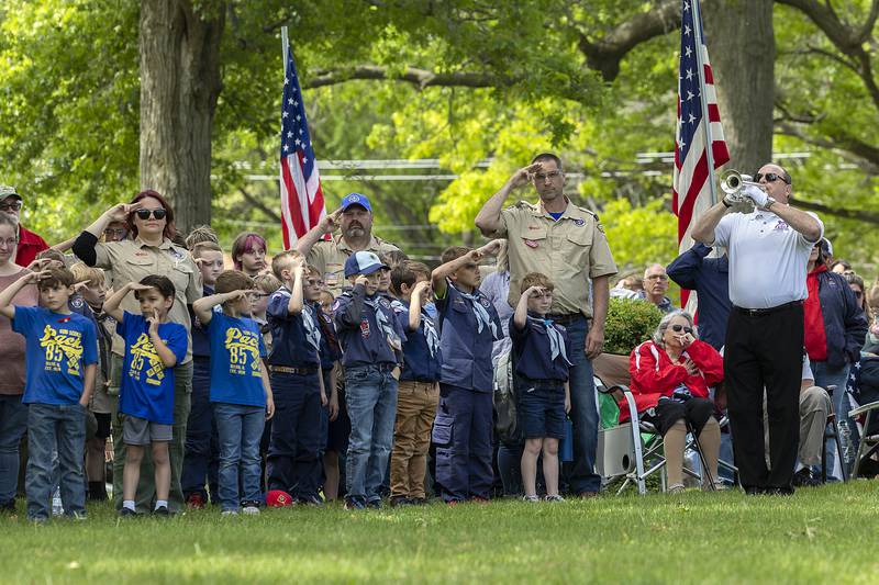 Scouts stand and salute as Chris Hammitt plays taps Monday, May 26, 2025, in recognition of Memorial Day.
