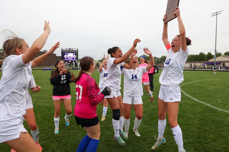 Peotone's Callie Weiss hoists the IHSA Class 1A Manteno Regional championship plaque in celebration with the team following the Blue Devils' 2-1 victory over Beecher on Friday, May 22, 2026.