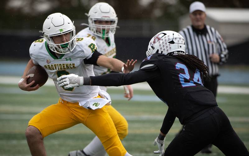 Providence Catholic's Dominic Vita, left, looks to block Kankakee's Isaiah Robinson, right, as he runs the ball during a Class 5A playoff game on Saturday, November 8, 2025.