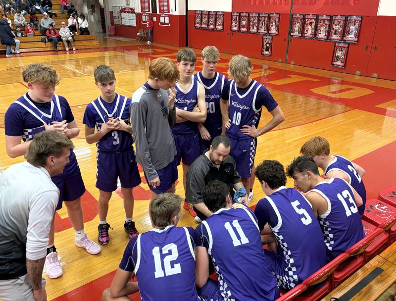 Wilmington boys basketball coach Doug Krop (center) talks things over with his Wildcats during a timeout Friday, Jan. 9, 2026, at Pops Dale Gymnasium in Streator.