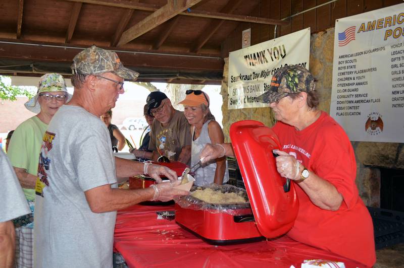 Forreston American Legion member Martha Hughes serves sauerkraut to fellow member, Harrell Wiggins, on Aug. 6 during Forreston Sauerkraut Days' American Legion Sauerkraut lunch.