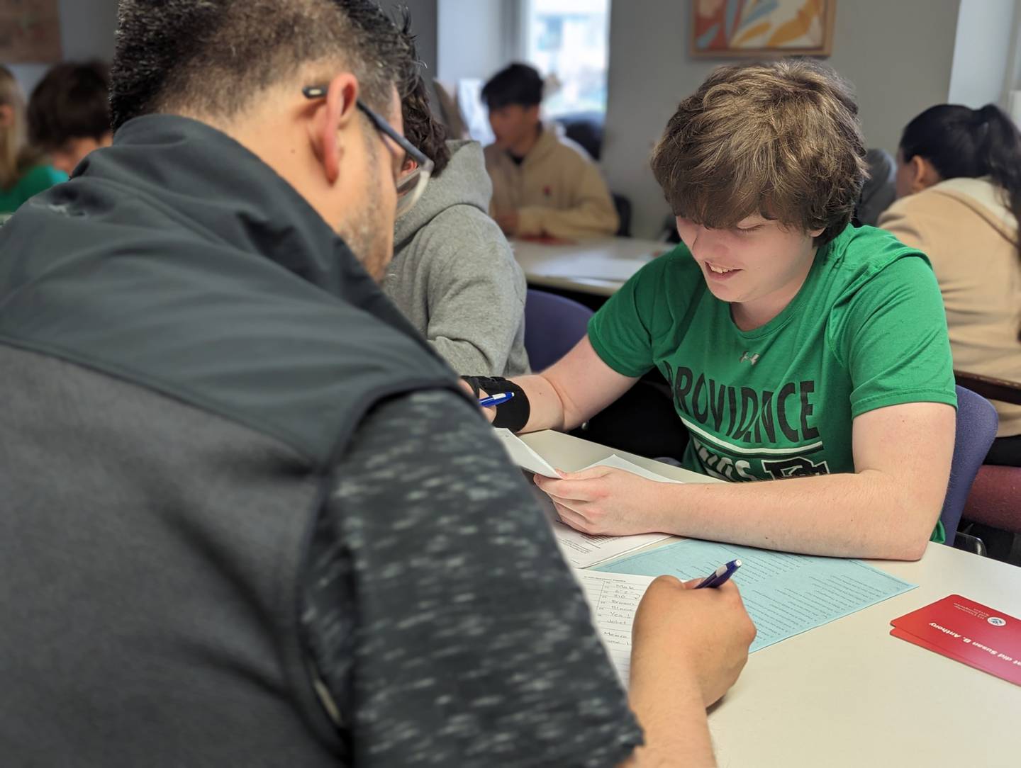 Mike Moss, member of the Spanish Honors Society at Providence Catholic High School in New Lenox, conducts a mock citizenship interview with a participant at the Spanish Community Center in Joliet.