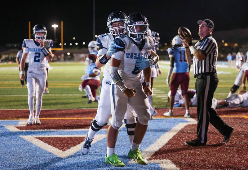Nazareth's Dylan Wellner, center, celebrates a touchdown with teammate Alex Harris during Nazareth's 33-12 victory over Kankakee on Friday, Aug. 29, 2025.