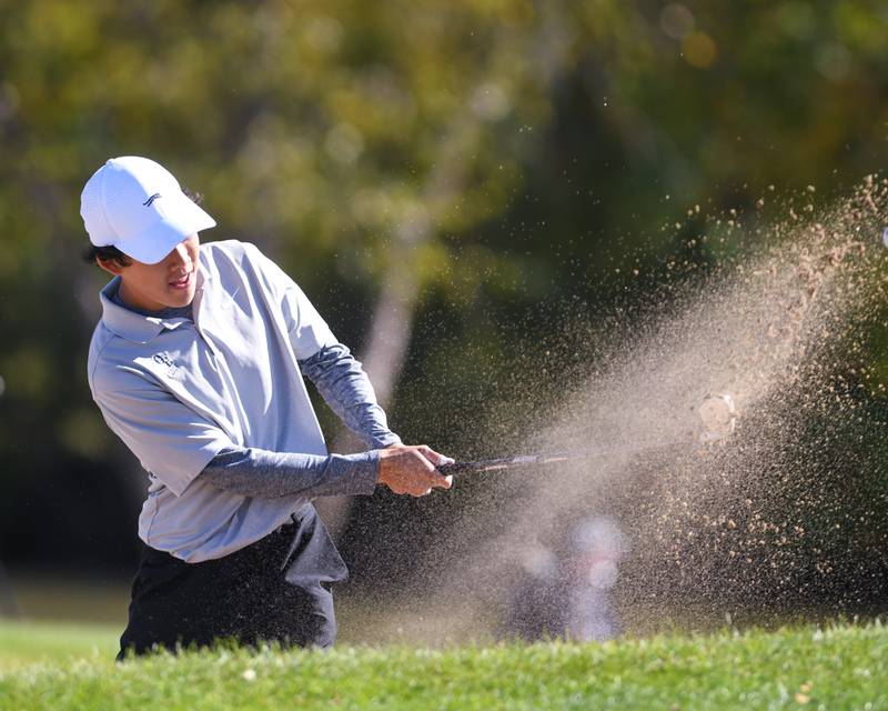 Oswego East's Logan Hong hits out of the sand trap on during the Class 3A sectional held at Blackberry Oaks Golf Course in Bristol.