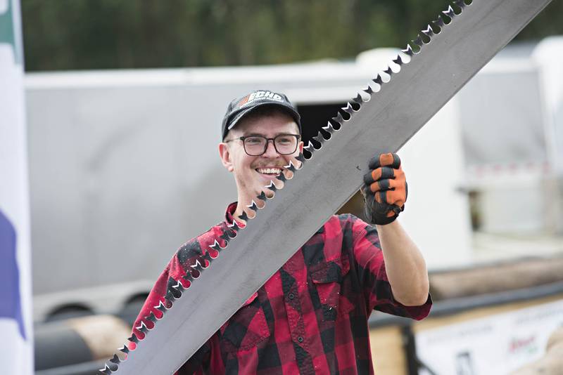 Tim Knutson shows off the two-person buck saw he'll be using with a volunteer in competition against Berard.