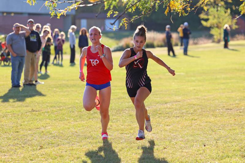 Bradley-Bourbonnias' Nora Hyma, right, overtakes Tri-Point's Grace Richie near the finish line in the girls 3-mile race during All-Area Cross Country meet on Wednesday, Oct. 8, 2025, at Kankakee Community College.