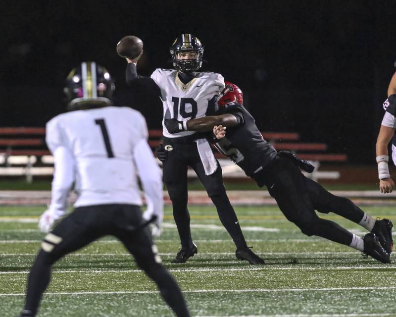 Glenbard North's Kyle Melody (19) throws a pass while being pressured by Yorkville's James Sapp Jr. (15) during Class 7A first round football game between Glenbard North at Yorkville. Friday, Oct 31, 2025 in Yorkville.