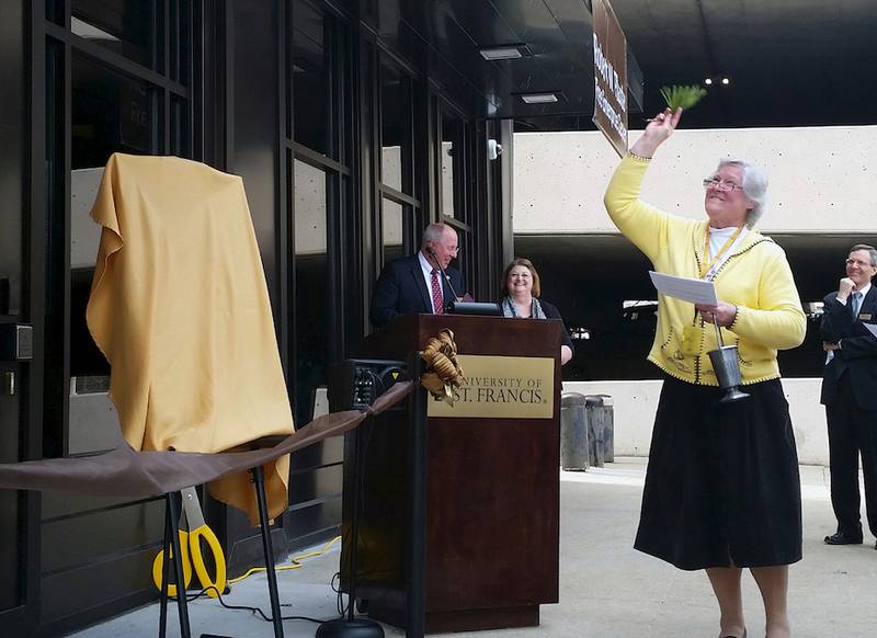 Sister Mary Elizabeth Imler, vice president for mission integration and university ministry for the University of St. Francis, blesses the Robert W. Plaster Free Enterprise Center.