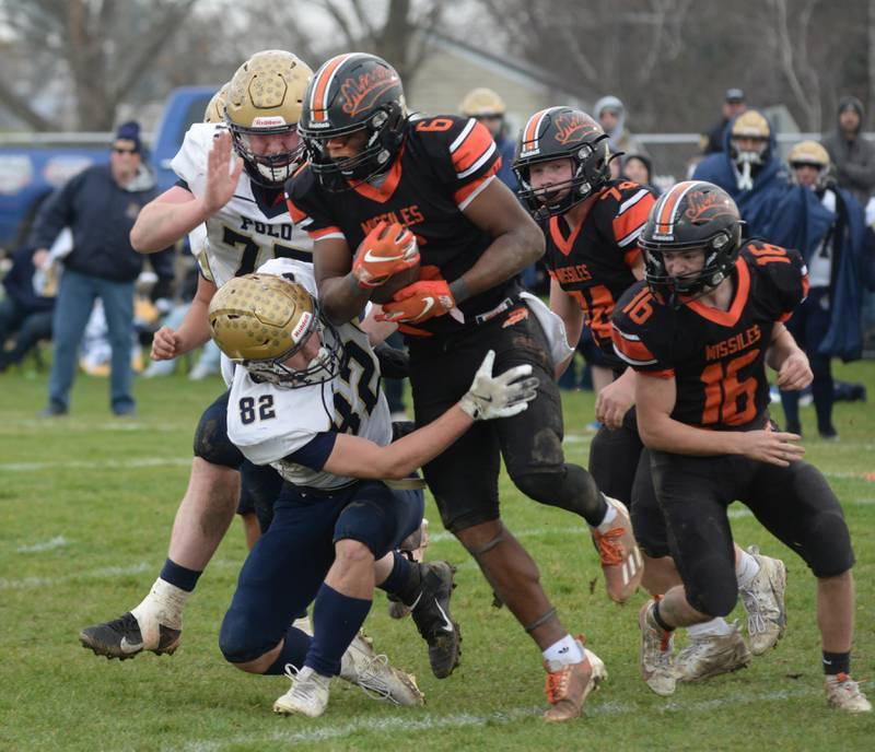 Milledgeville's Micah Toms-Smith (6) runs with the ball as Polo's Kailin Gulbranson (82) defends during 8-man playoff action on Saturday, Nov. 16, 2024 at Milledgeville.