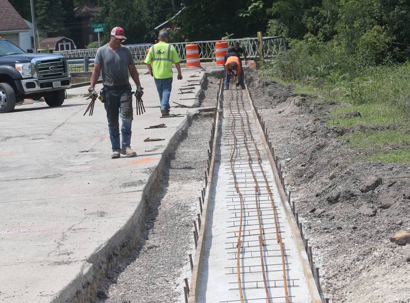 Crews prepare to pour a new sidewalk at the site of the Utica retail plaza on Monday, July 15, 2024 near the intersection of Mill and Grove Streets. Workers poured a sidewalk and have started the preliminary work on the Market on Mill area. The project is scheduled to be completed just before Burgoo.
