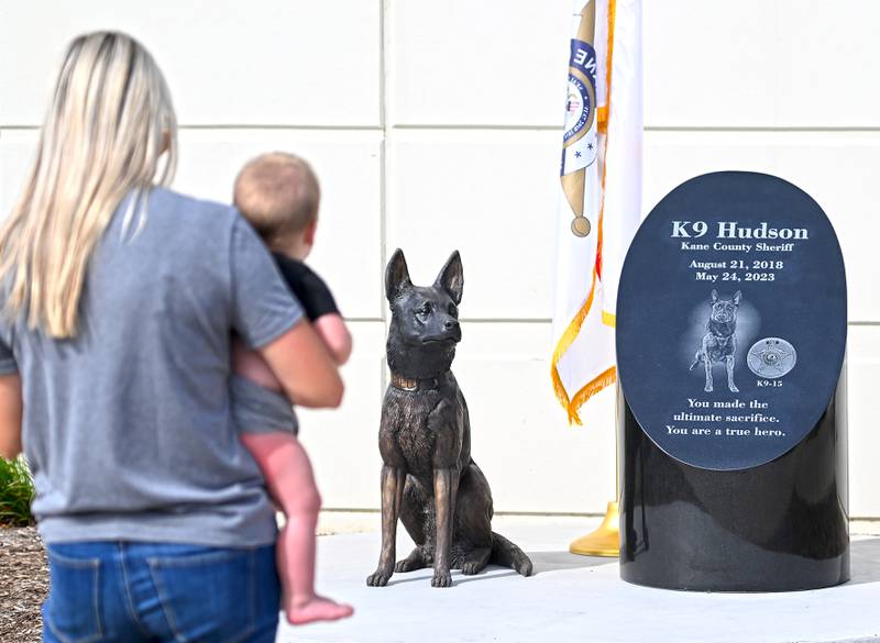 Rachel Weston, holding son Lane, 10 months, takes a picture of the monument dedicated to Kane County sheriff's office police dog, Hudson, who was killed in the line of duty last year. Her husband Luke was Hudson's handler.