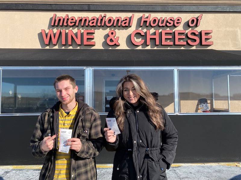 International House of Wine & Cheese employees Landon Fischer, left, and Sarah Mirocha pose outside the store where a $500,000 winning Lucky Day Lotto ticket was sold for the Jan. 12, 2025, drawing.
