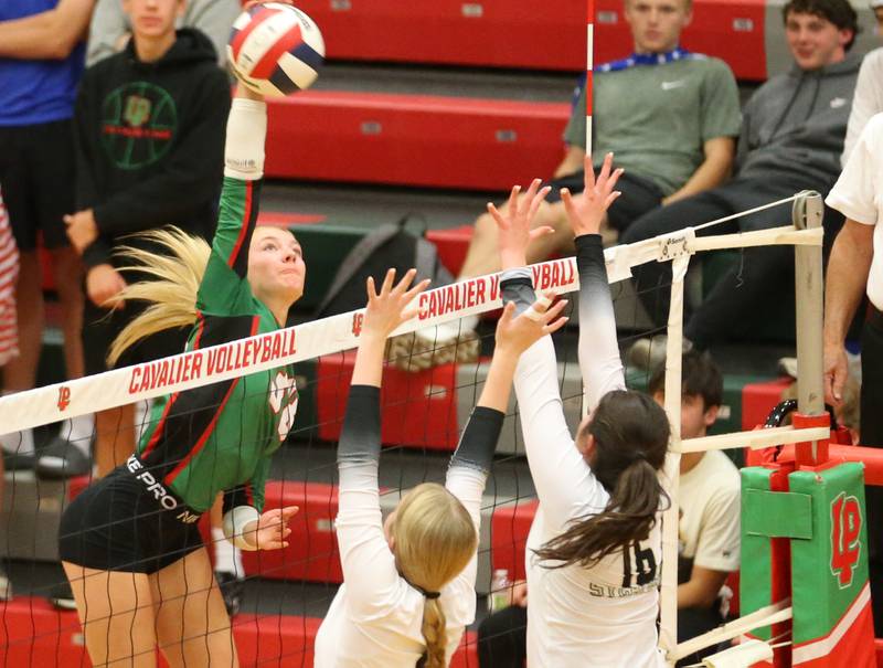 L-P's Aubrey Duttlinger sends a kill past Sycamore's Maddie Patton and teammate Norah Chami on Tuesday, Oct. 15, 2024 in AJ Sellett Gymnasium at L-P High School.