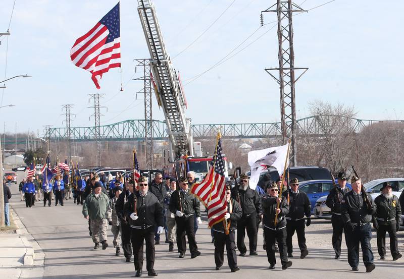 Veterans march underneath a giant American Flag during the annual Pearl Harbor parade and memorial service on Saturday in Peru. This year marks the 83rd anniversary of the Dec. 7, 1941, attack on Pearl Harbor.