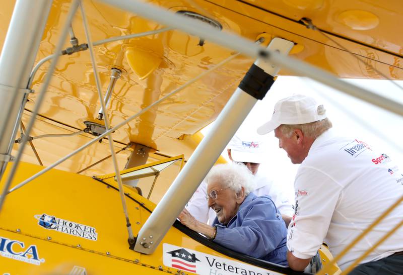 Helen Ehlers, 99, of Wheaton is eased into her seat with the help of pilot Darryl Smith as they prepare for a Dream Flight at the DuPage Airport in West Chicago on Saturday, July 29, 2023. The plane is a 1942 open cockpit Boeing Stearman, the same airplane used to train military aviators in the 1940s. The flights were courtesy of Ageless Aviation Dreams Foundation, a non-profit organization to honor U.S. military veterans living in long-term care facilities. Ehlers is a United States Marine Corps veteran.