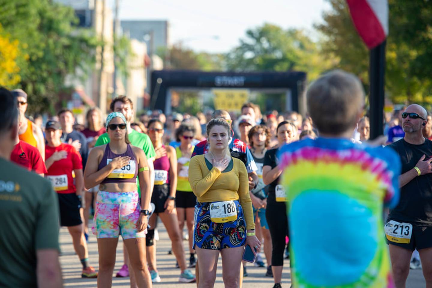 Runners listen to the national anthem ahead of the start of the DeKalb Corn Classic 5K and 10K race on Sept. 28, 2025, in DeKalb.