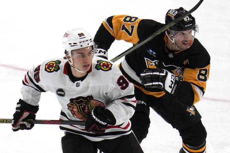 Chicago Blackhawks' Connor Bedard (98) and Pittsburgh Penguins' Sidney Crosby (87) skate during the second period in Pittsburgh, Tuesday, Oct. 10, 2023.