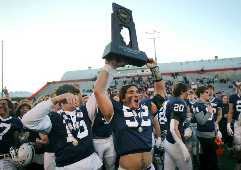 Cary-Grove's Will Barcy brings the trophy to the fans Saturday, Nov. 25, 2023, after their win over East St. Louis in the IHSA Class 6A state championship game in Hancock Stadium at Illinois State University in Normal.
